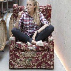 Doris Frühwirth, sitting in an armchair in the winery's barrel cellar