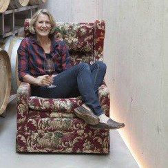 Gerlinde Frühwirth, sitting in an armchair in the winery's barrel cellar