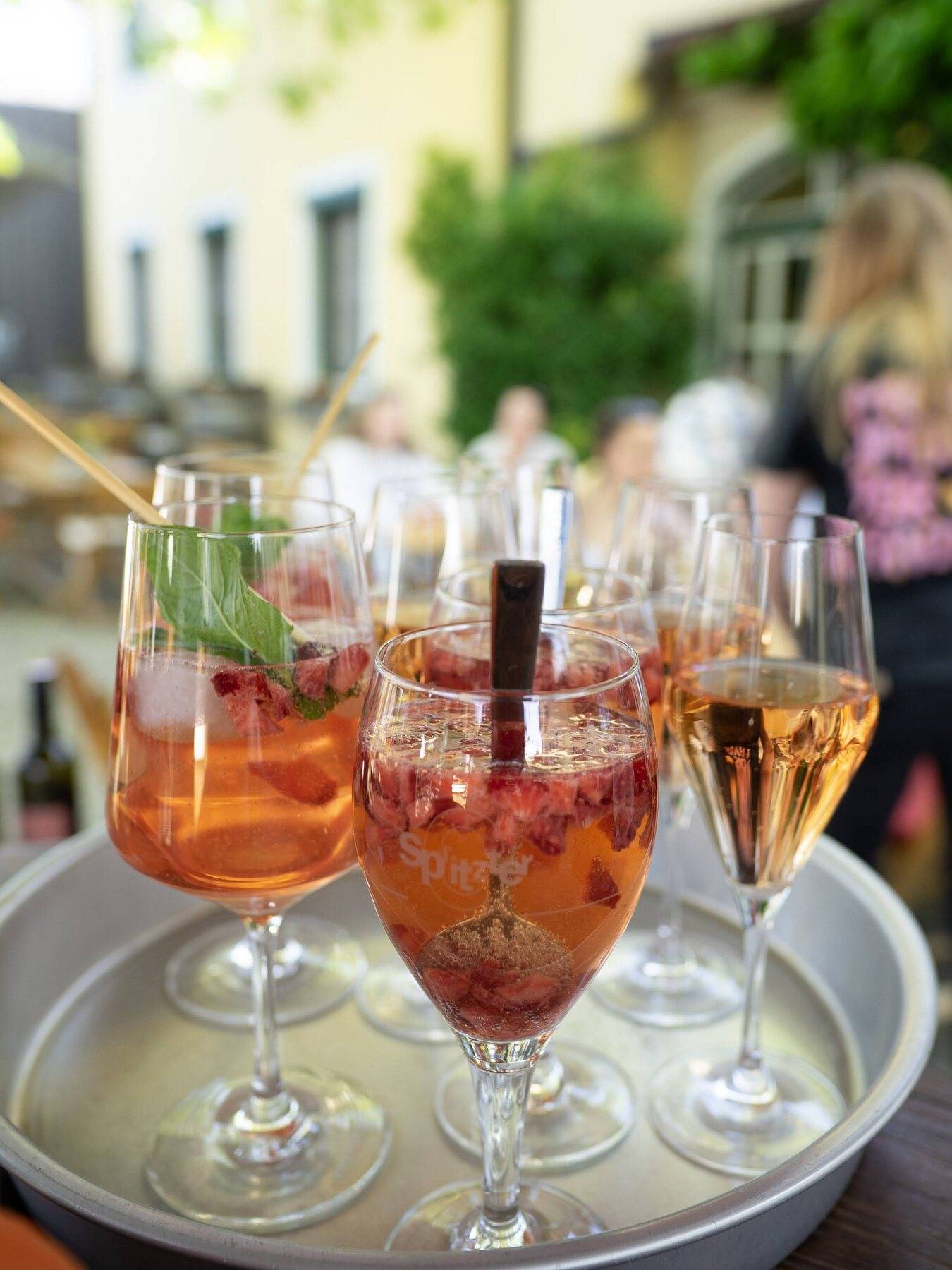 Ein Tablett mit Erdbeer-Spritzern und Rosé steht bereit, dahinter unser Gastgarten