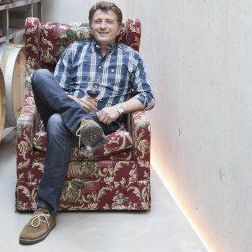 Johann Frühwirth, sitting in an armchair in the winery's barrel cellar