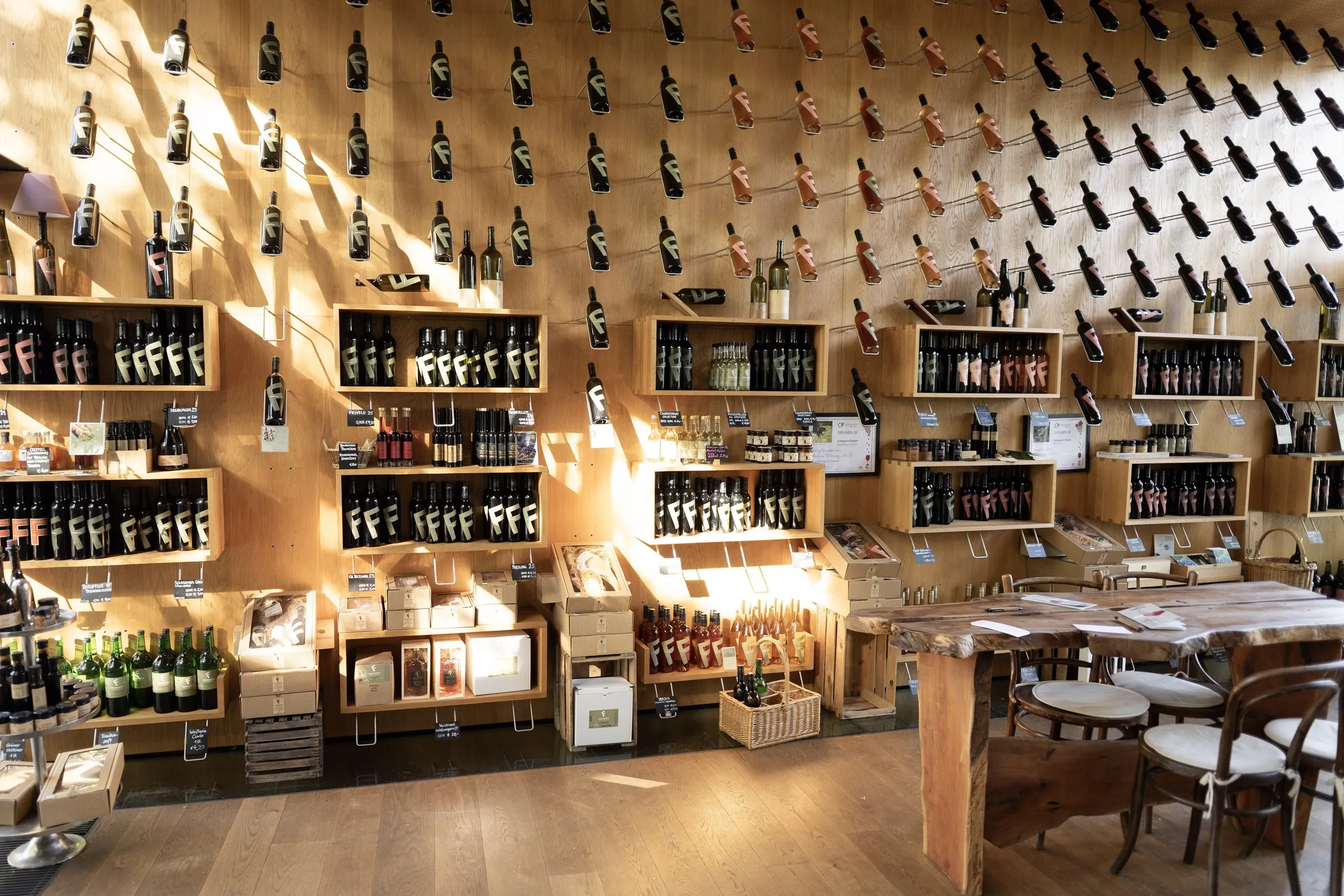 Verkaufs- und Verkostungsraum mit Weinregalen und Flaschen aus Holz